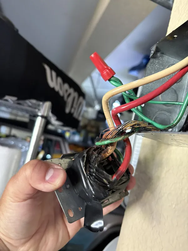 Burnt outlet removed from the box, showing heat damage