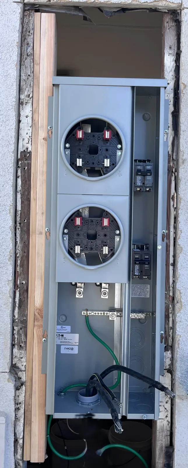 Dual meter socket installed in a wall opening