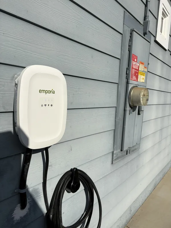 Emporia EV charger installed on an exterior wall beside the meter